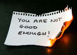 A burning paper with "You Are Not Good Enough" written on it